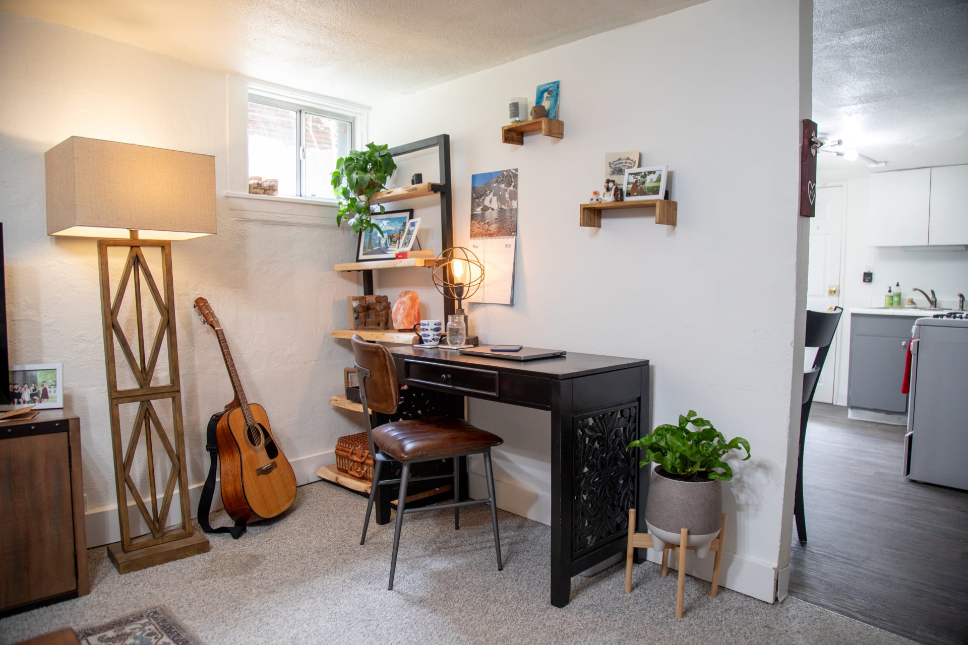 Corner window scene featuring the Rupa Writing Desk accompanied by floor lamp and bookshelf
