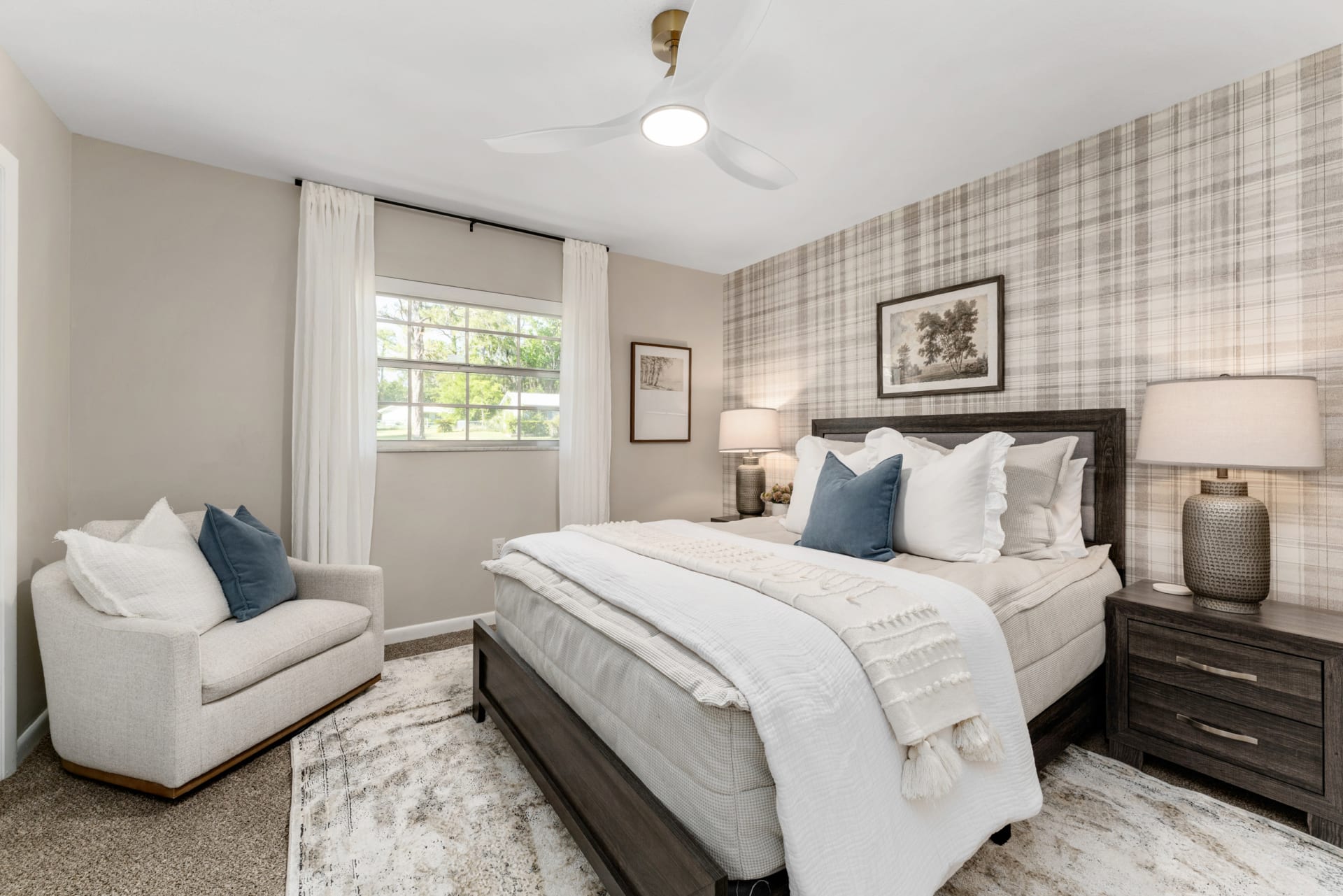 A dark wood bed with a gray fabric headboard Bed in Kelli Bateman's Airbnb third bedroom