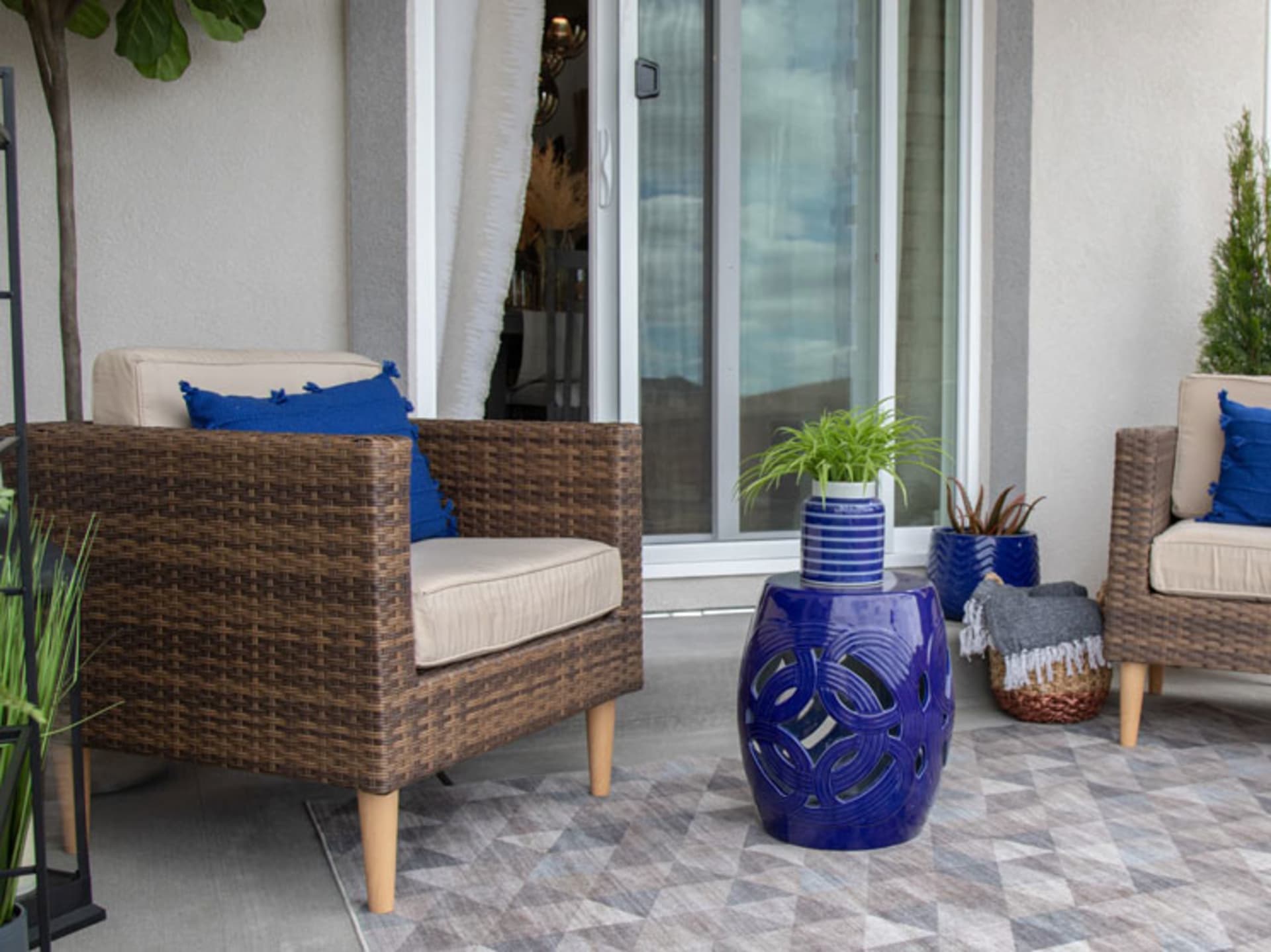 The San Bruno 4 Pc. Patio Set accessorized with vibrant blue accents on a patio