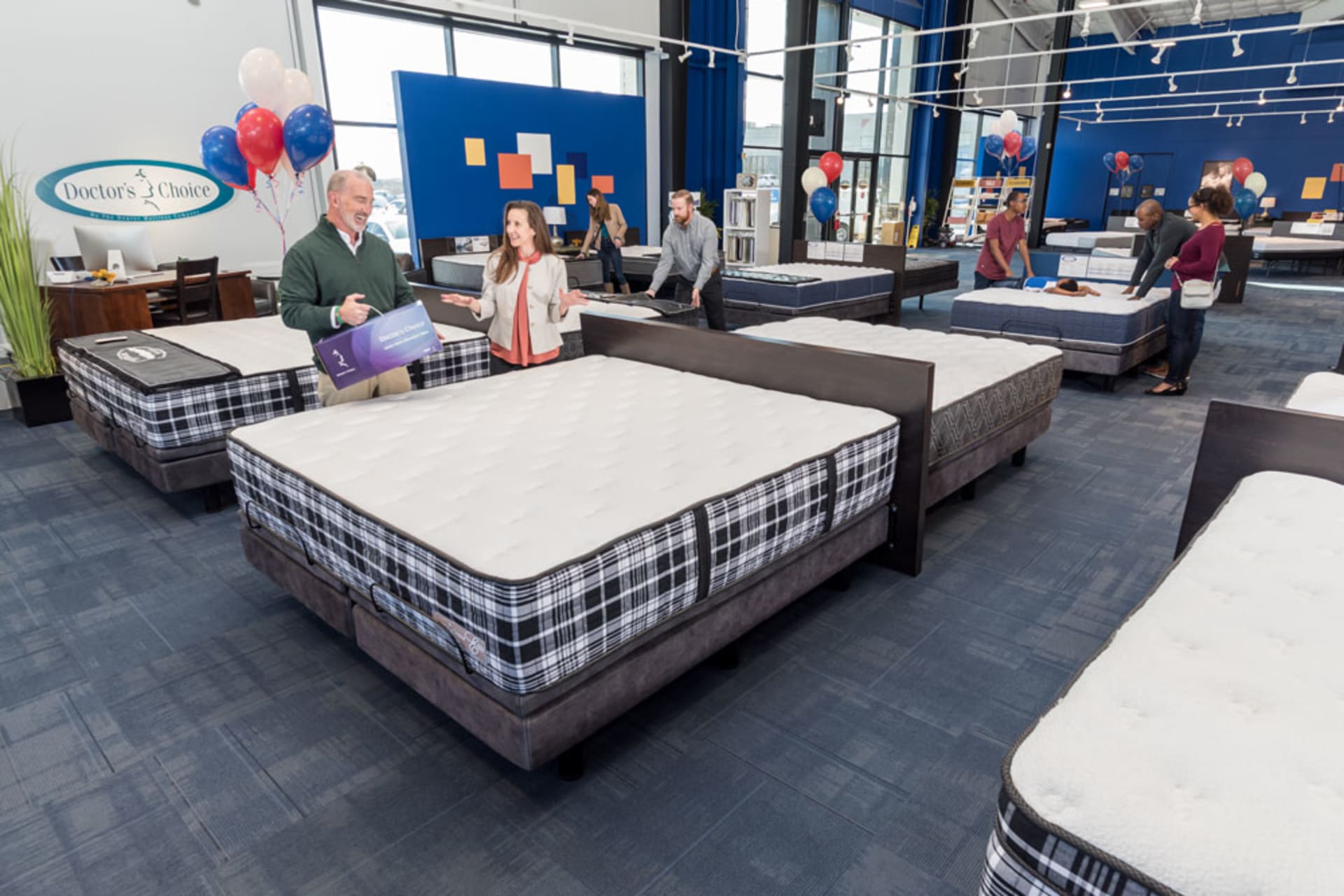 Doctors Choice Mattress section in Denver Mattress store with customers and red white and blue balloon