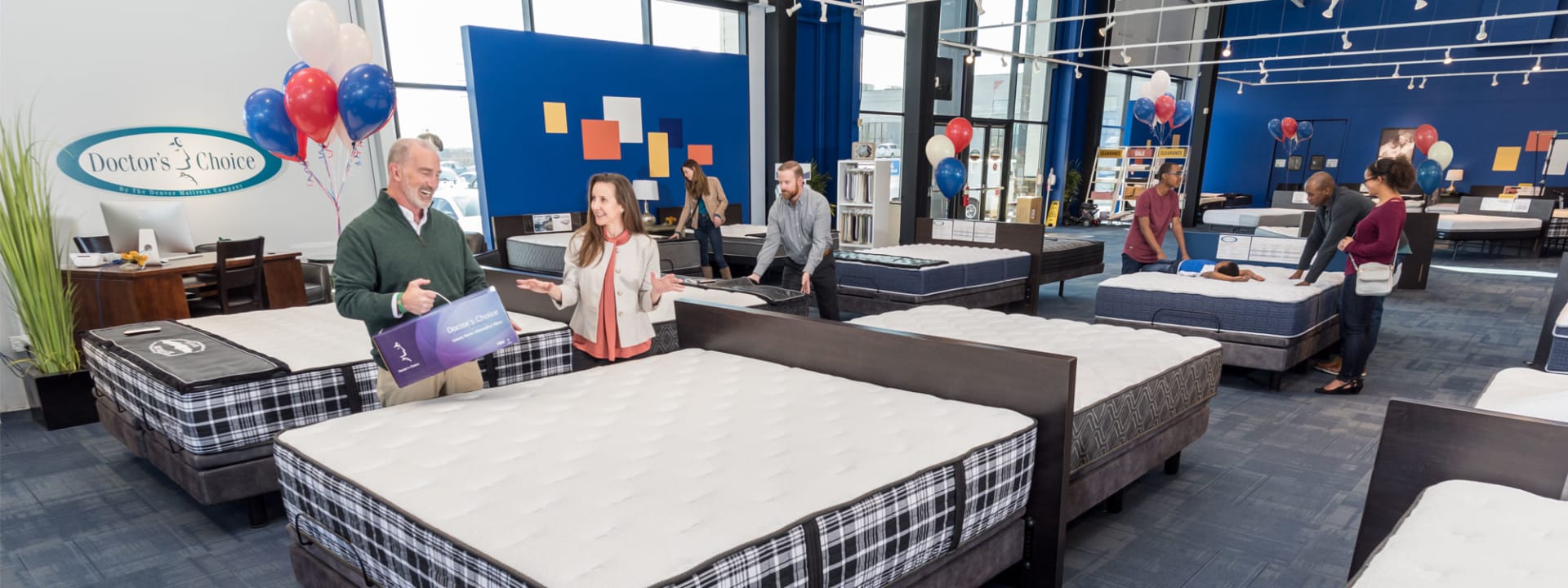 Doctors Choice Mattress section in Denver Mattress store with customers and red white and blue balloons