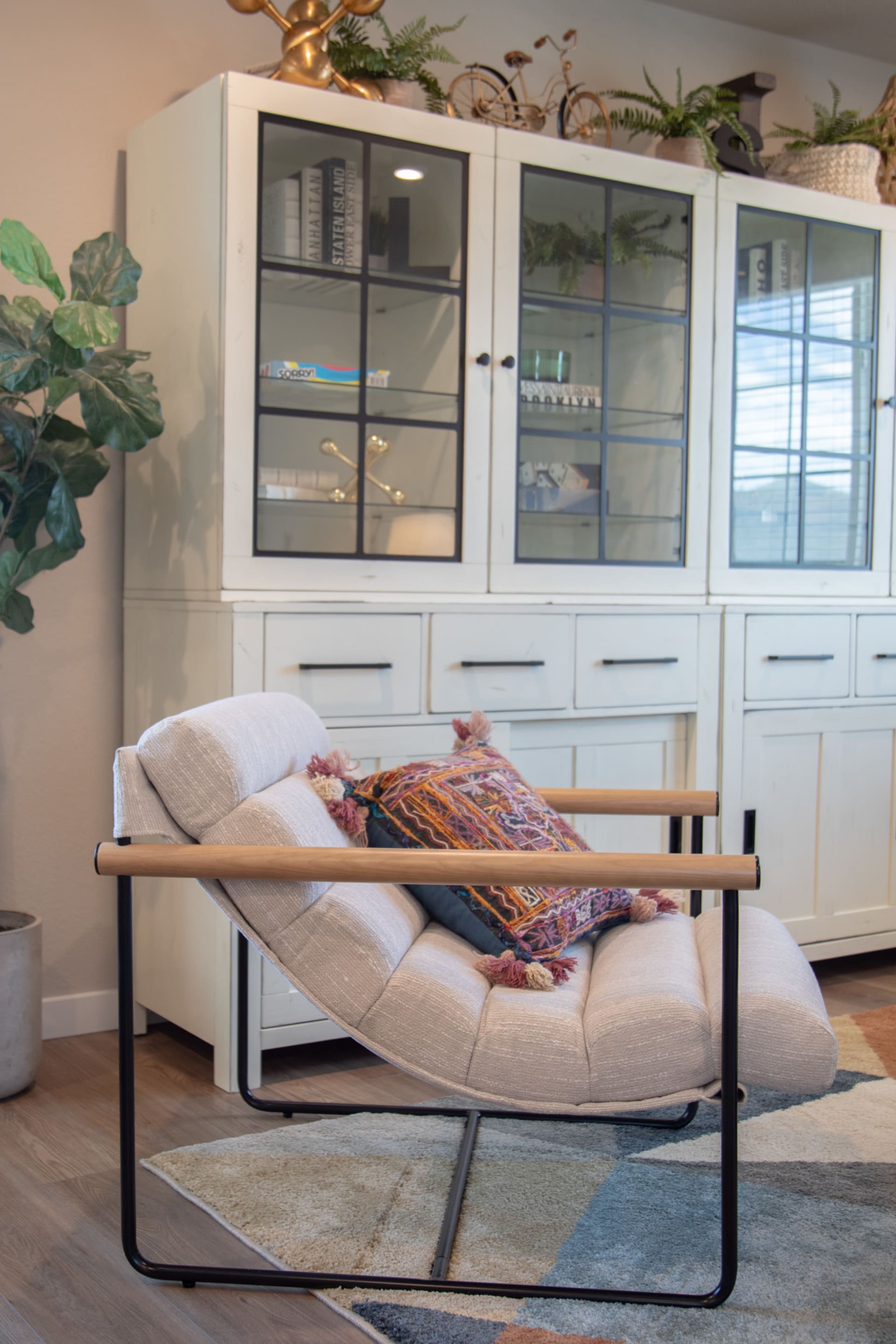 A contemporary accent chair with a hanging upholstered seat and comfy white fabric
