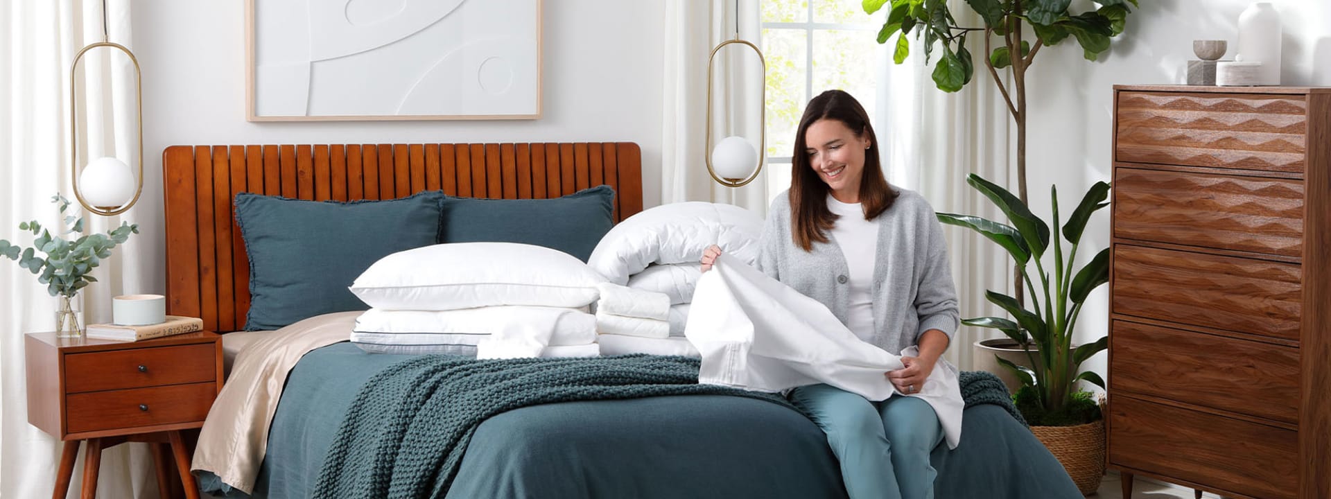 Woman Folding Sheets In Bedroom