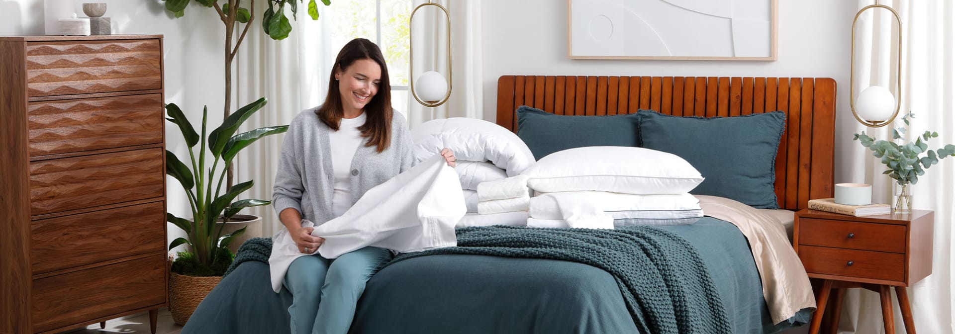 Woman with sheets and pillows on bed