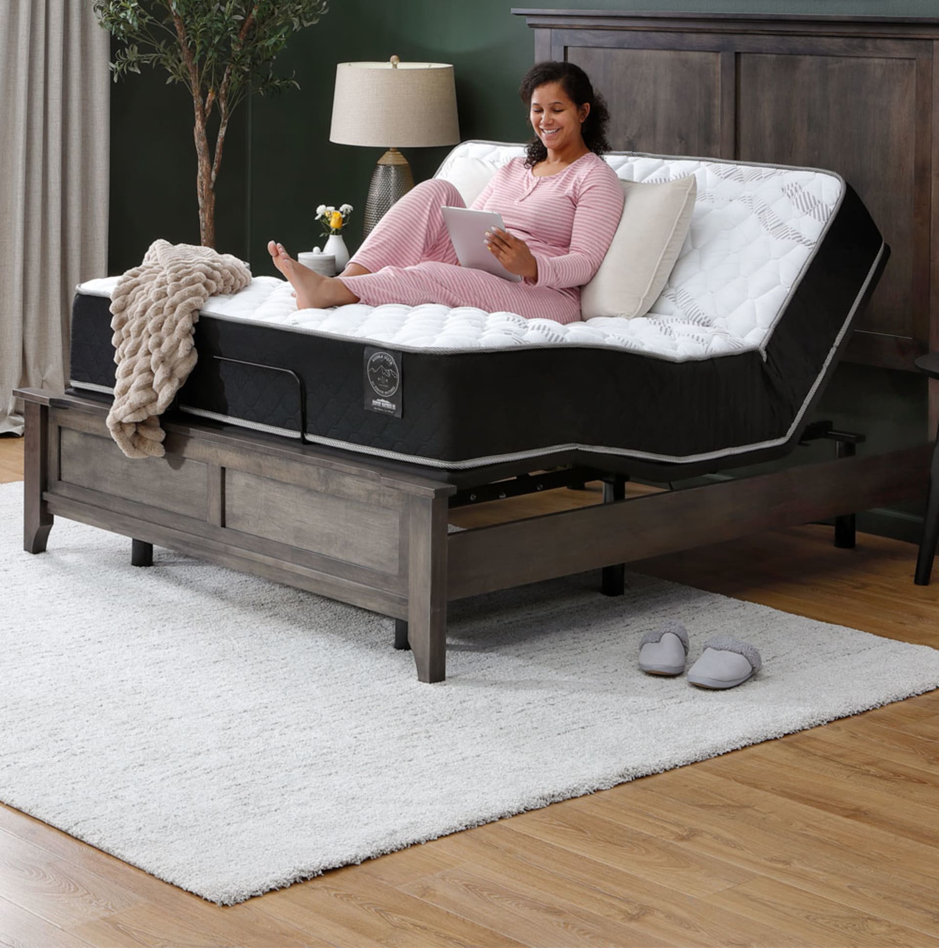 Woman Sitting on Buena Vista Mattress on Adjustable Base in Bedroom