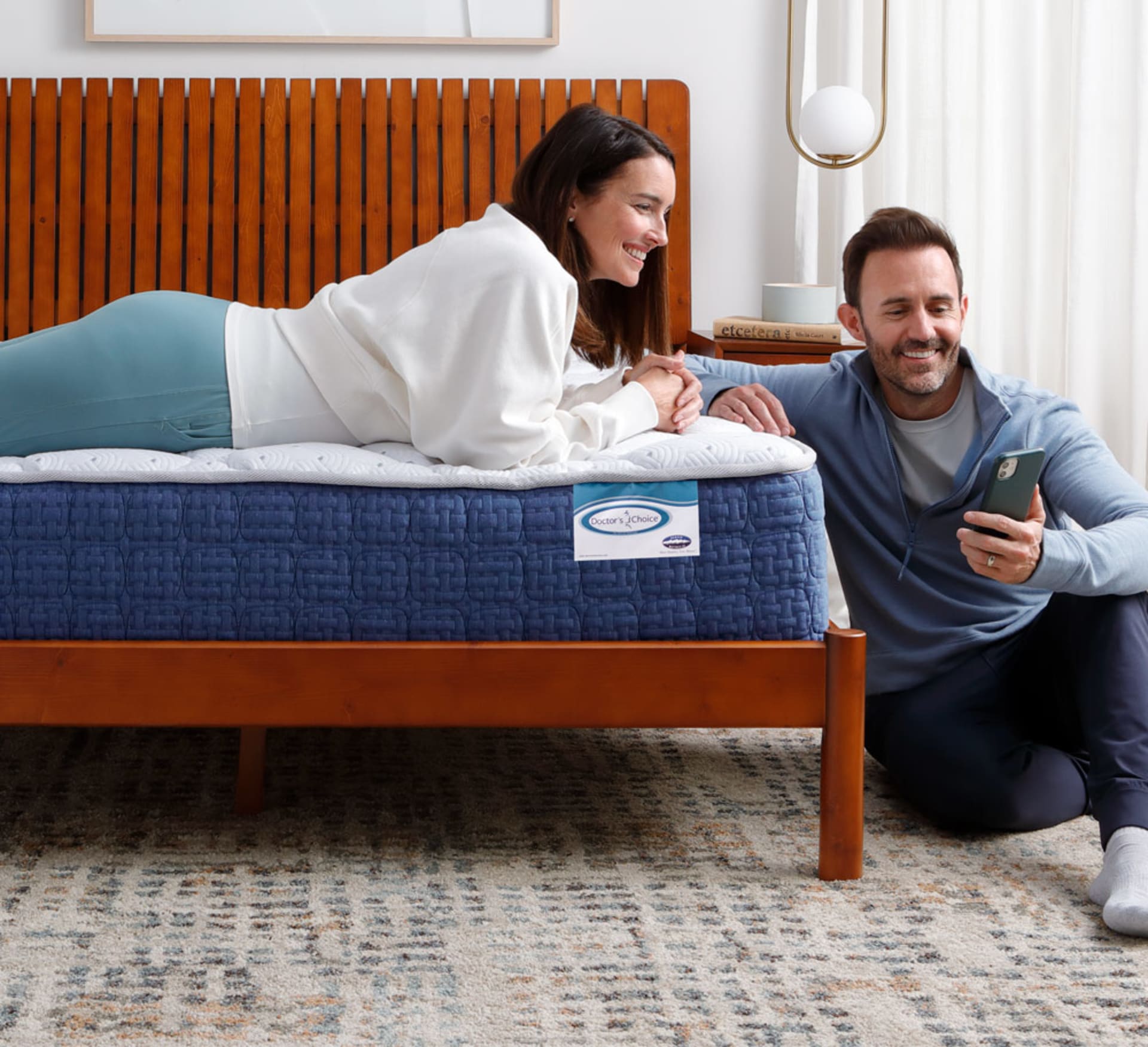 Couple laying on bed looking at phone