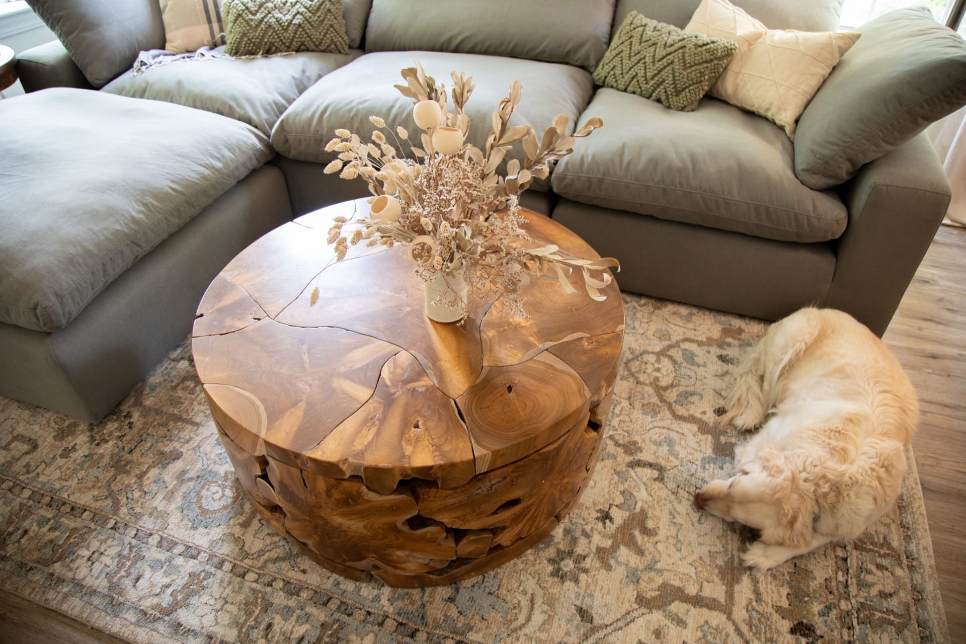 A round wood coffee table, the Jakarta Coffee Table, in a living room
