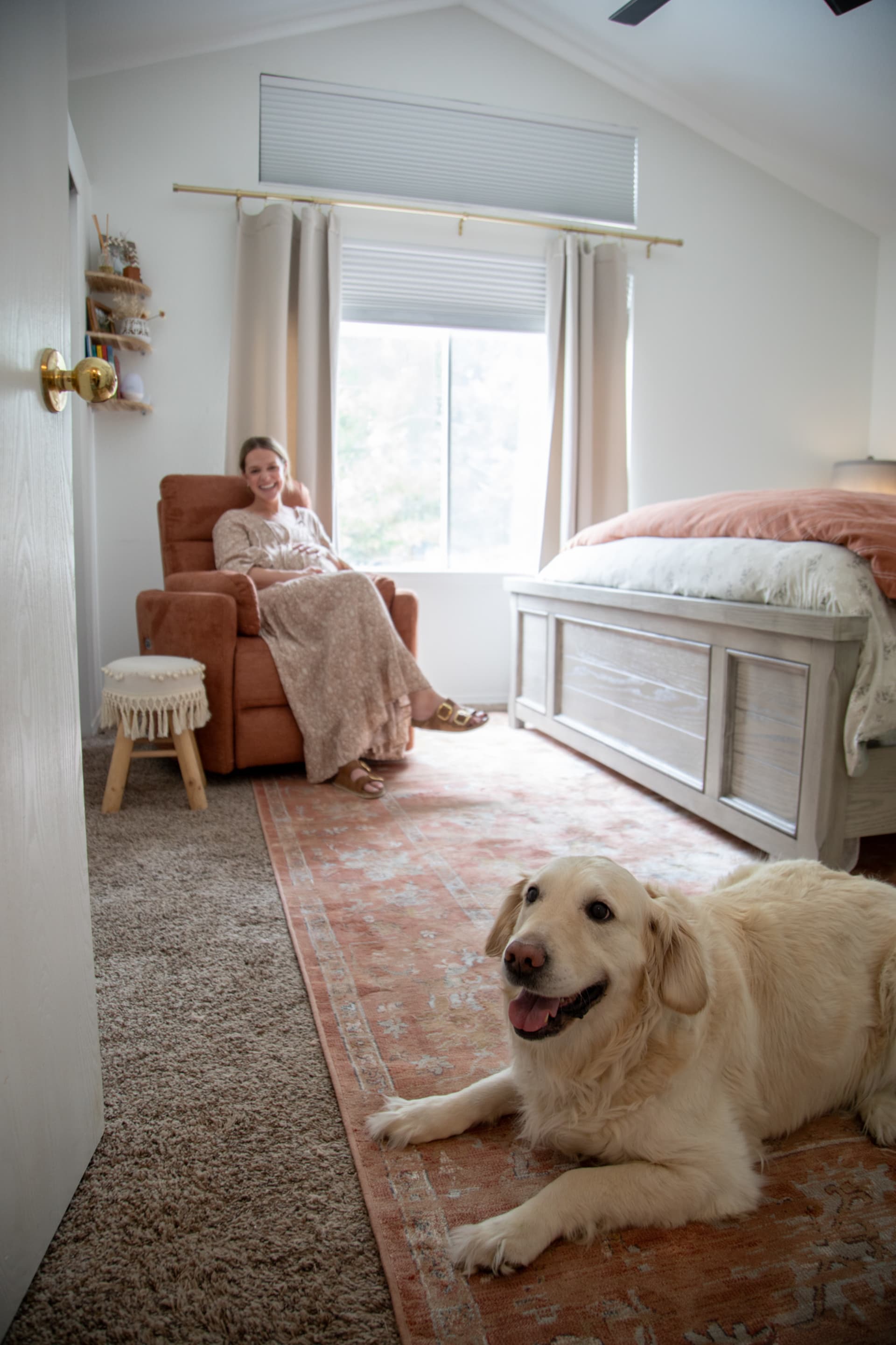 Woman sitting on Cooper Swivel Glider Recliner with dog in bedroom