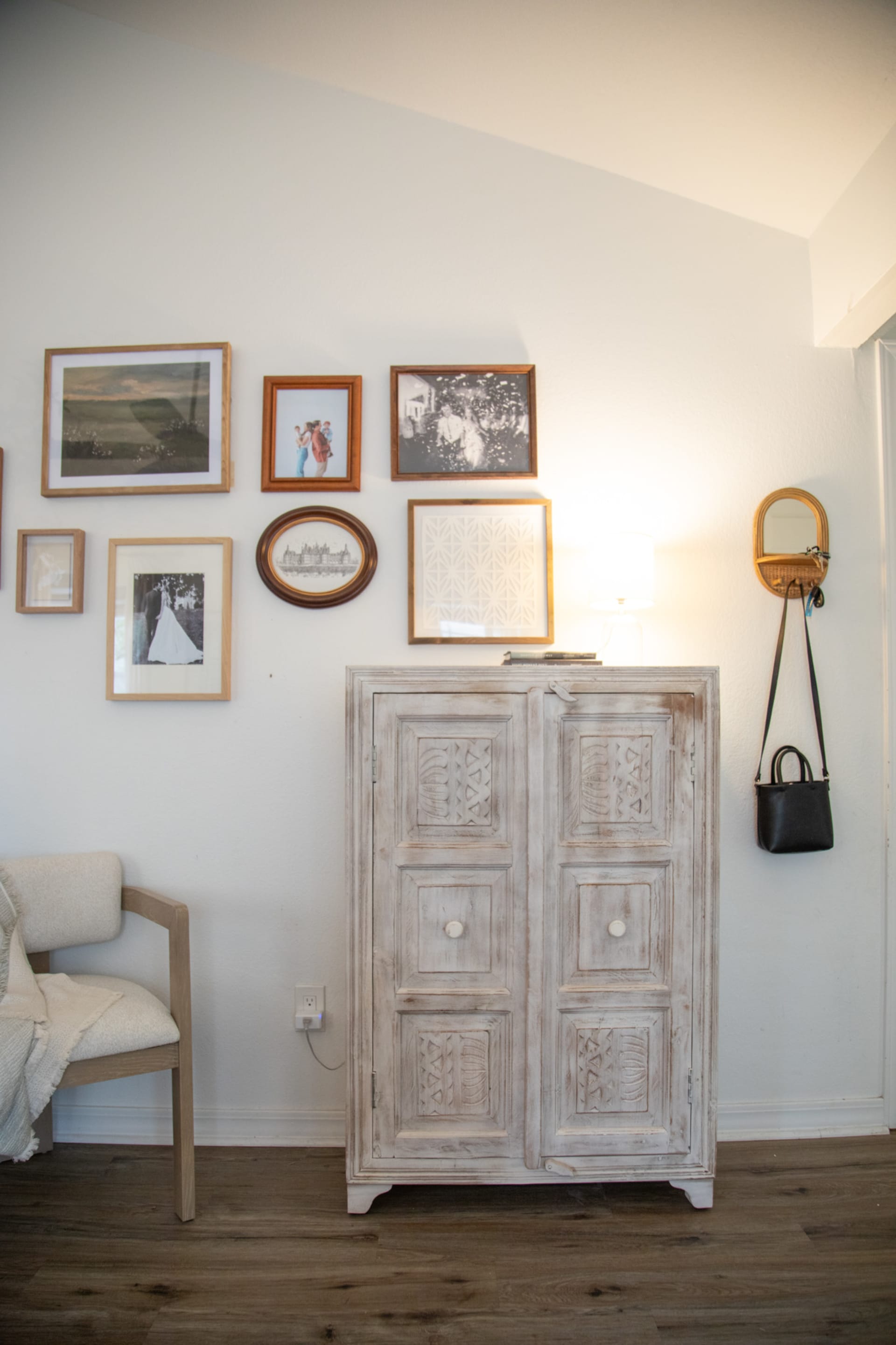 A weathered wood cabinet in an entryway beneath family photos