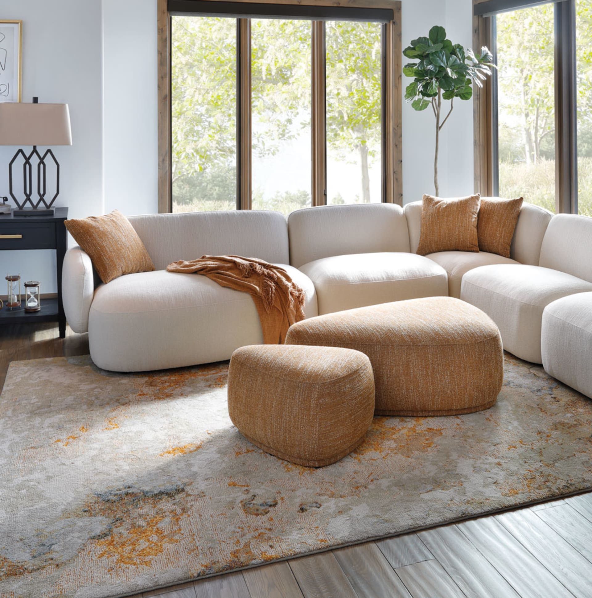 White Rounded Cushion Sectional with gold pillows and Ottoman in Living Room