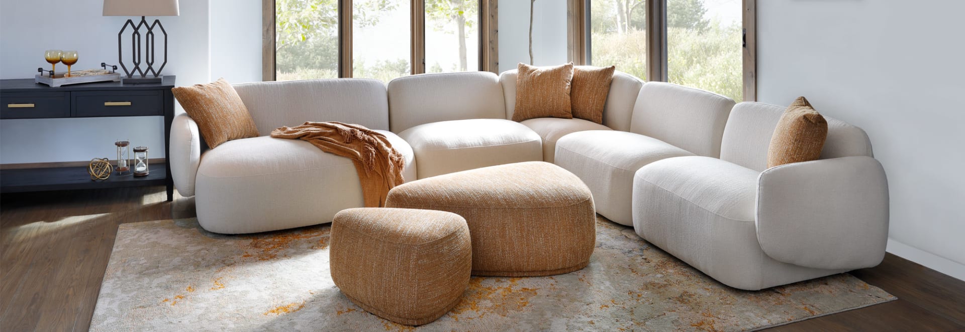 White Rounded Cushion Sectional with gold pillows and Ottoman in Living Room