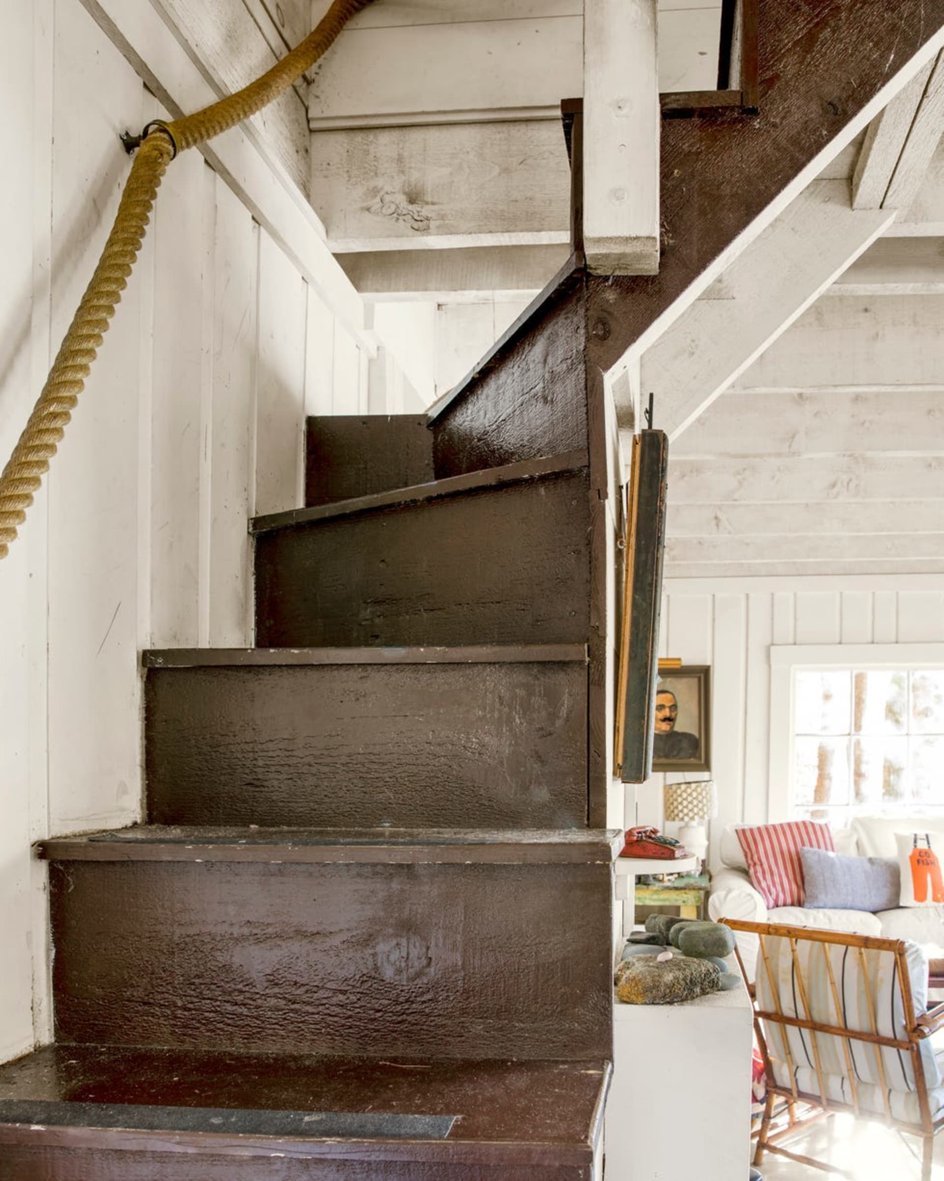 A stairwell with a coastal themed rope handrail