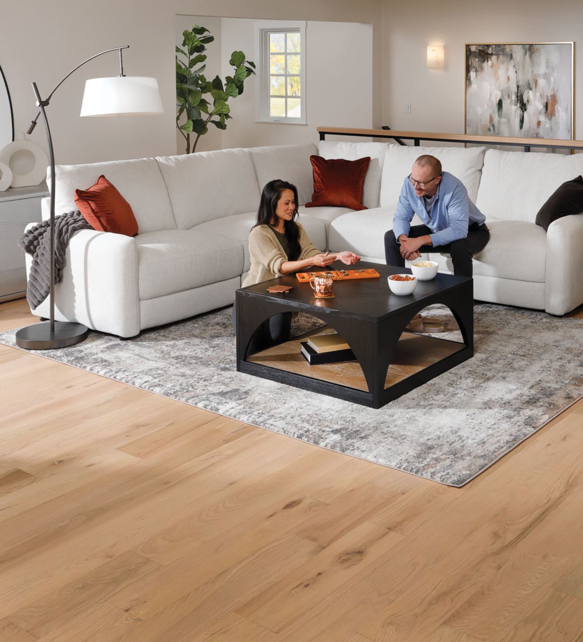 couple playing board game on white Power Reclining sectional in Living Room