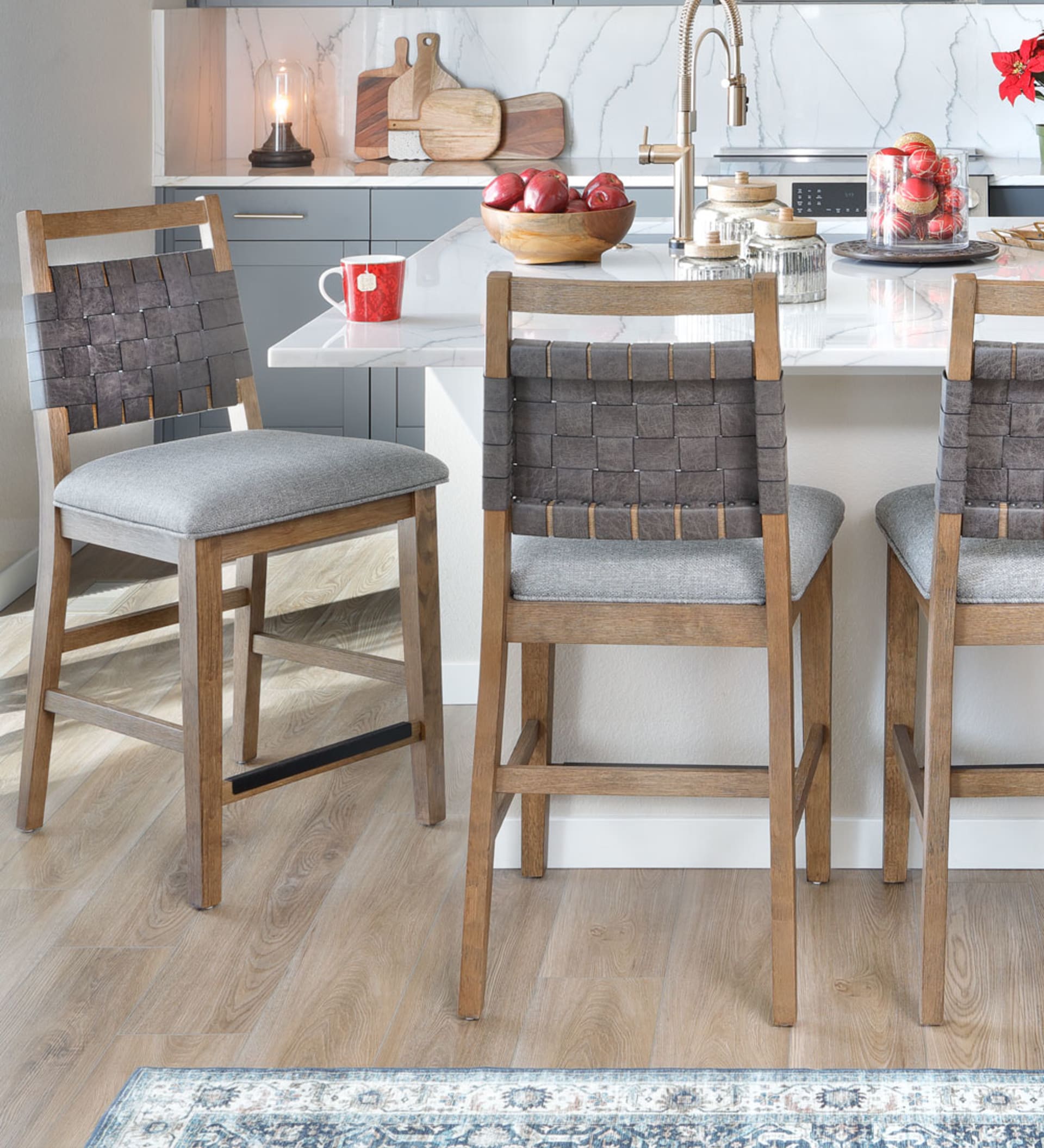 Traverse City Dining Group, mid-toned wood with gray cushions and woven leather chair backs in christmas dining room.