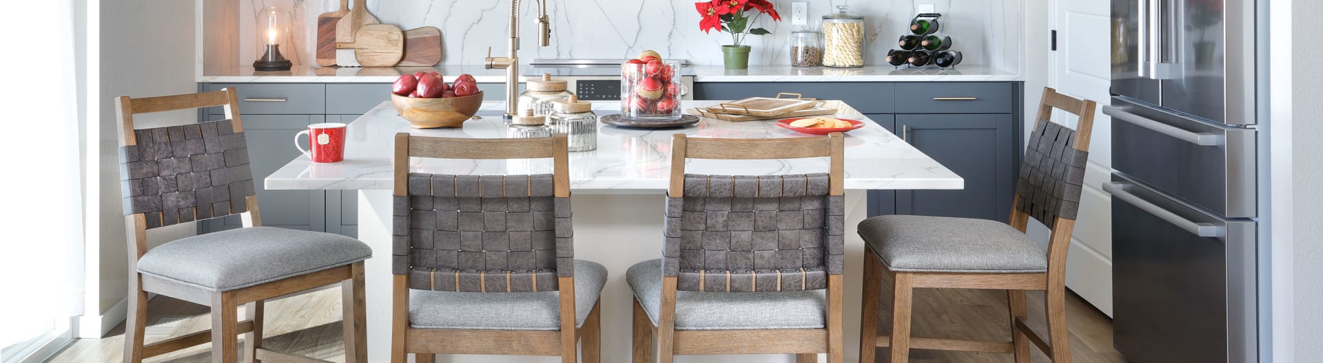 Traverse City Dining Group, mid-toned wood with gray cushions and woven leather chair backs in christmas dining room.