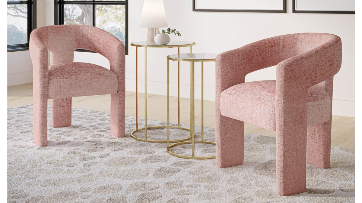 Two pink upholstered dining chairs serving as accent chairs with round side tables