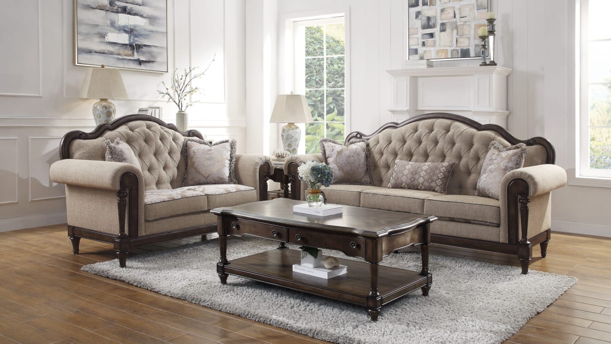 Traditional beige tufted sofa and loveseat around a rectangular wood coffee table in living room window scene