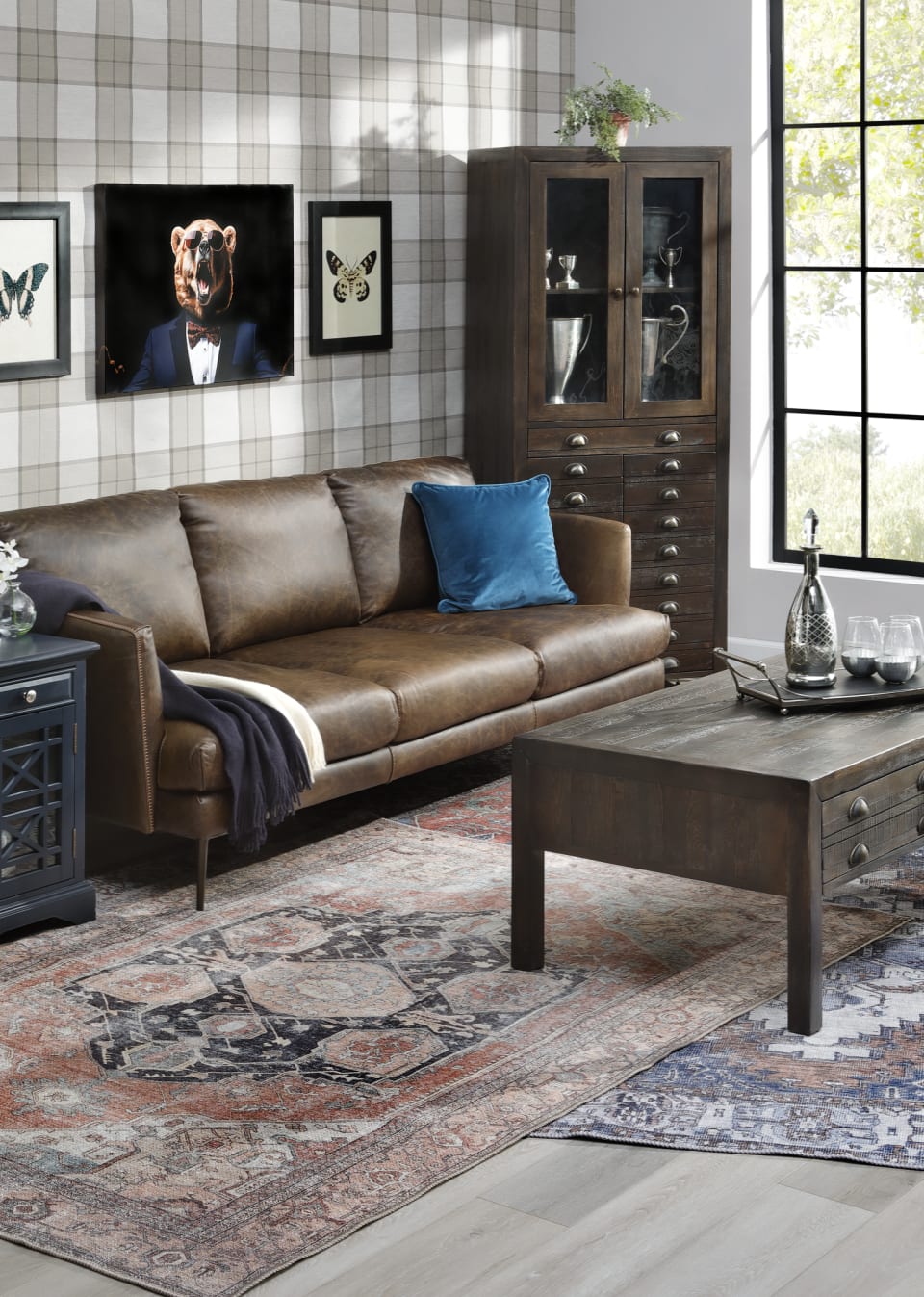 Brown Leather Sofa with Apothecary style media case and windowed navy side table against beige plaid wall