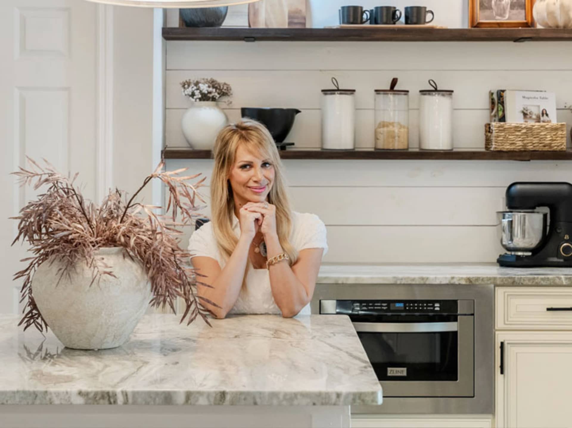 Interior designer Kelli Bateman sat at the marble island of her home kitchen