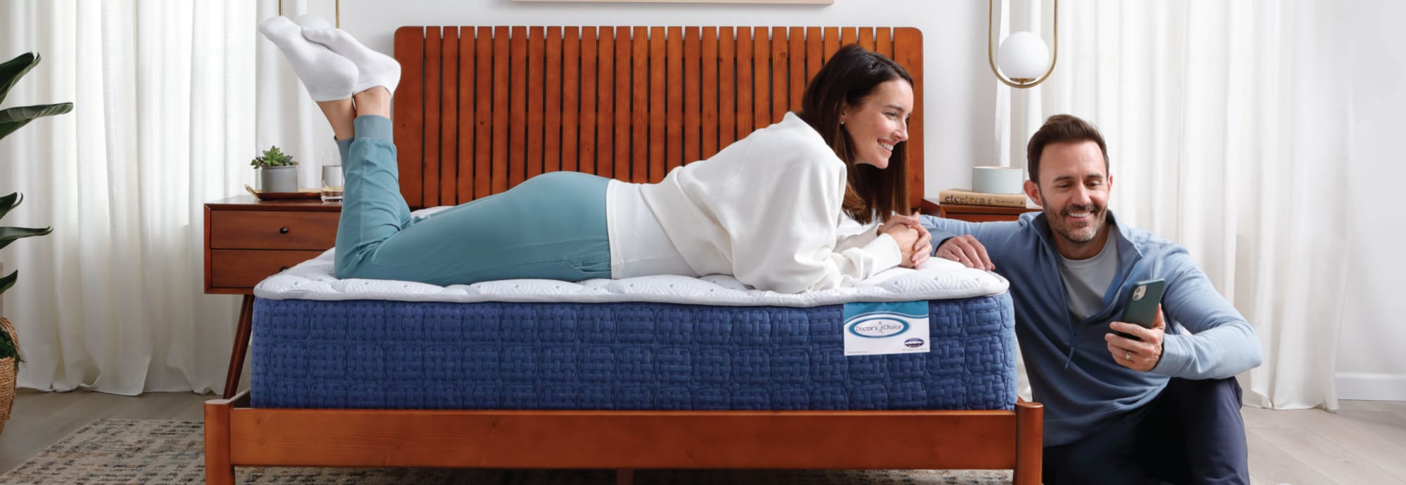 Couple laying on bed looking at phone